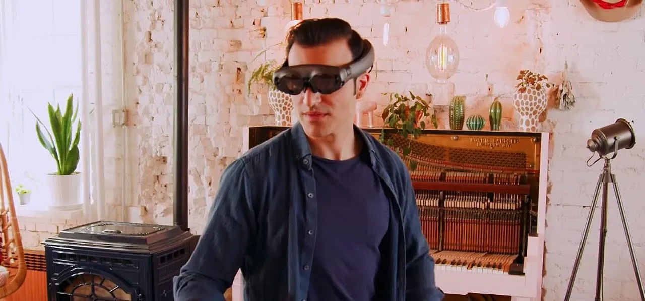 Person wearing augmented reality glasses in a modern interior setting.