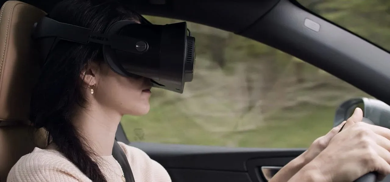 Woman wearing a virtual reality headset while driving.