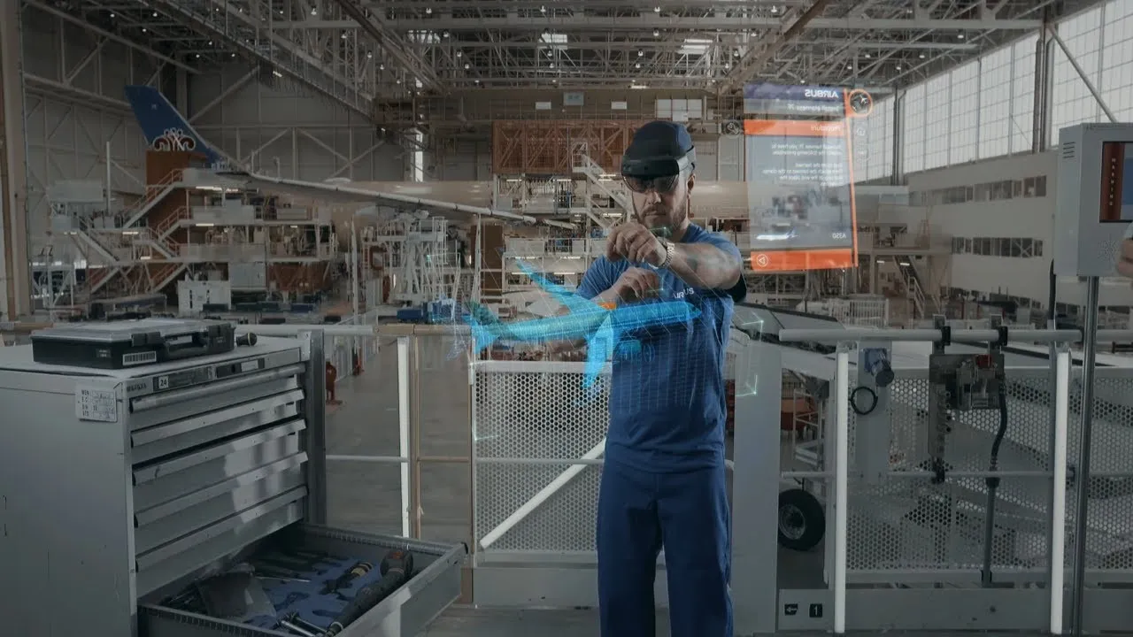 Technician using augmented reality tools in an aircraft maintenance facility.