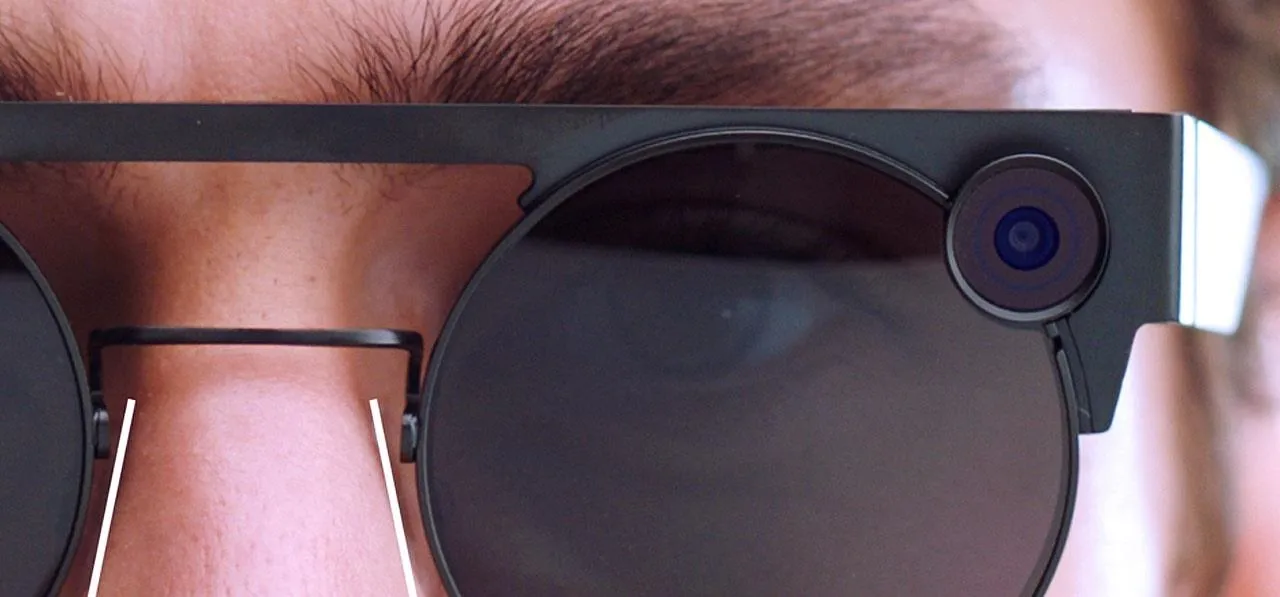 Close-up of a person wearing smart glasses with a camera.