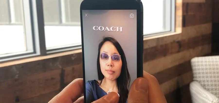 Woman taking a selfie with stylish sunglasses in a modern setting.
